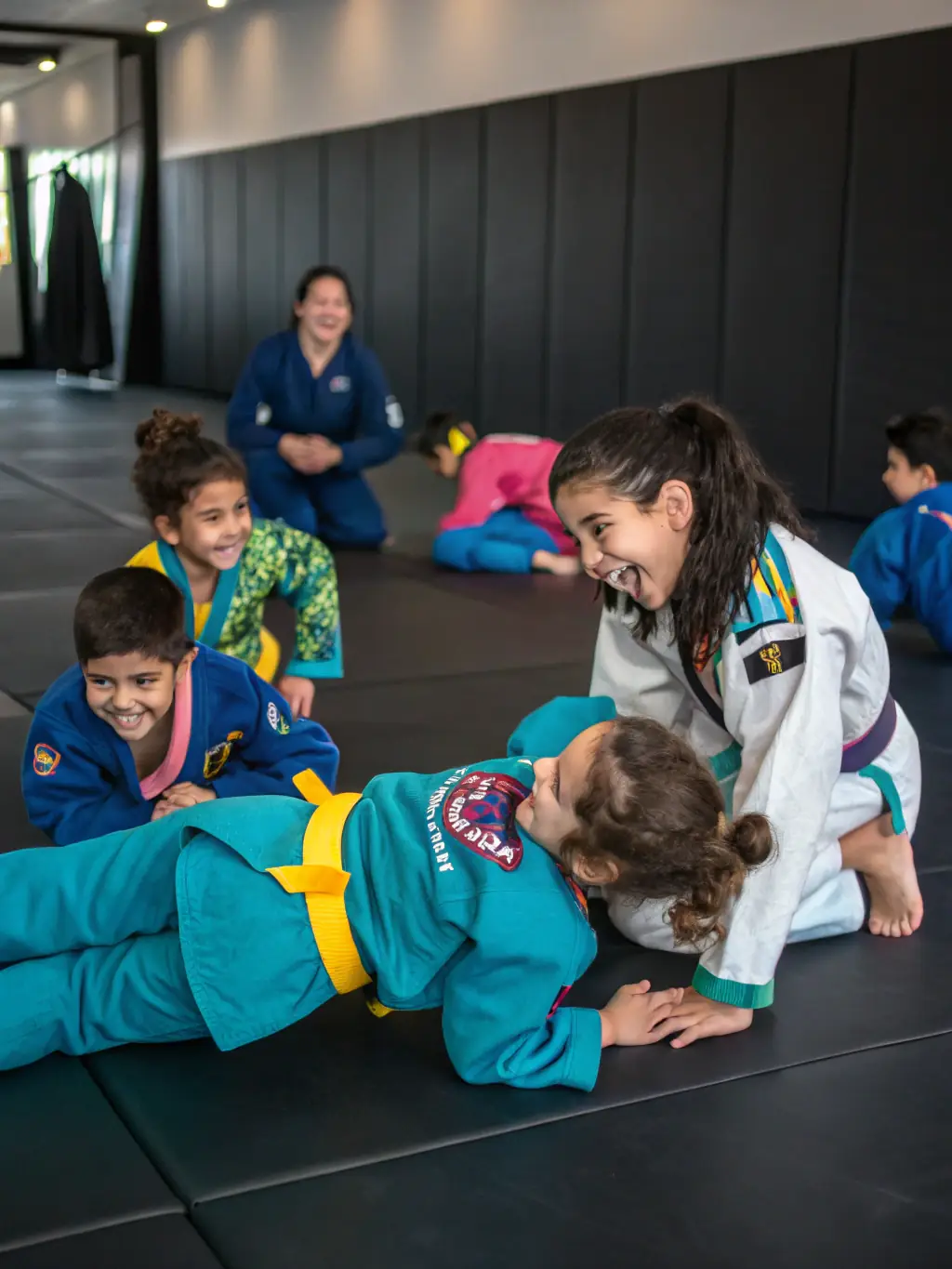 A diverse group of CARBON BJJ students of varying skill levels laughing and supporting each other during a water break in class.